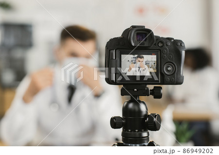 Doctor recording video about medical face mask Doctor recording video about medical face mask 86949202