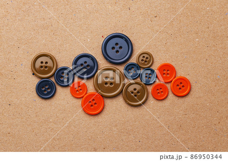 Set of multicolored buttons on beige background Set of multicolored buttons on beige background 86950344