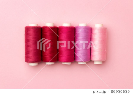 Set of threads spools on pink background Set of threads spools on pink background 86950659