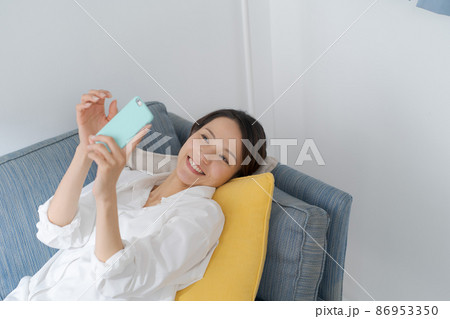 ソファでスマホを見る女性 ソファでスマホを見る女性 86953350