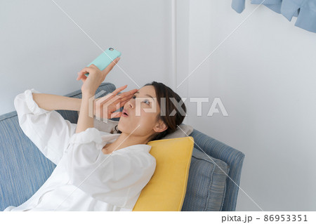 ソファでスマホを見る女性 ソファでスマホを見る女性 86953351