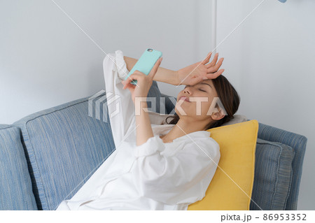 ソファでスマホを見る女性 ソファでスマホを見る女性 86953352