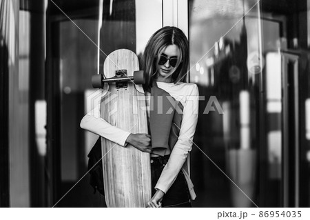 Lifestyle portrait of young woman with longboard. 86954035