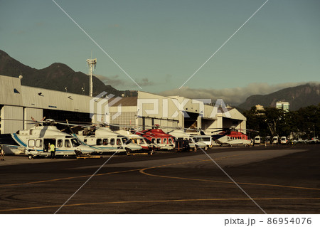 Hangar with helicopters at sunset. 86954076