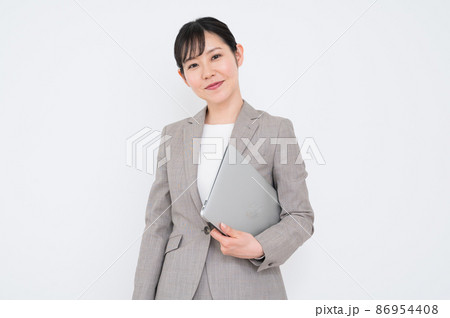 ノートパソコンを脇に抱えてポーズを取る女性 ノートパソコンを脇に抱えてポーズを取る女性 86954408