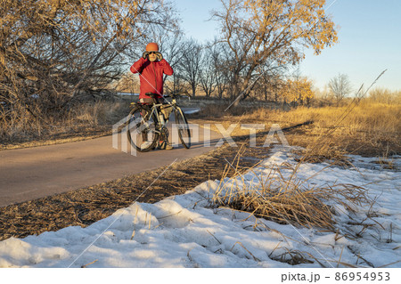 senior male cyclist with his touring bike on a biking trail senior male cyclist with his touring bike on a biking trail 86954953