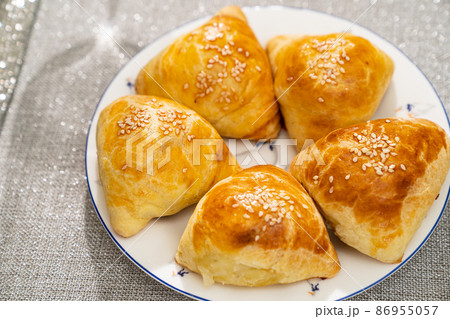 Samsa on plate. fried in oil or baked national oriental dish with salty filling Samsa on plate. fried in oil or baked national oriental dish with salty filling 86955057