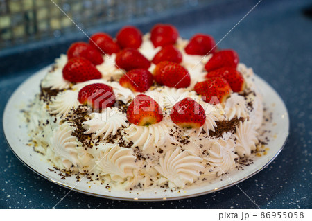 cake decorated with whipped cream and fresh strawberries. homemade dessert. cake decorated with whipped cream and fresh strawberries. homemade dessert. 86955058