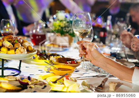 hands with glasses above the festive table hands with glasses above the festive table 86955060