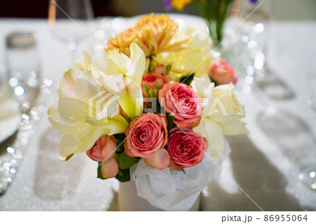 Beautiful bouquet of colorful flowers in a hat box on the dining table. Beautiful bouquet of colorful flowers in a hat box on the dining table. 86955064
