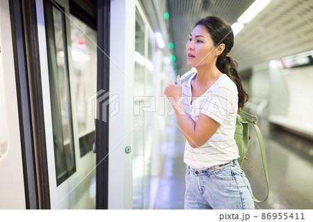 Woman getting on train in subway station 86955411