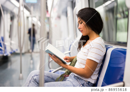 Woman reading book in subway train Woman reading book in subway train 86955618