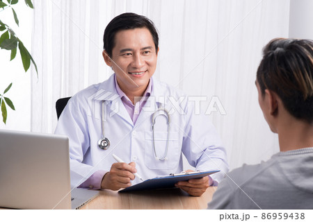 Confident asian male doctor discussing diagnosis with patient in office 86959438