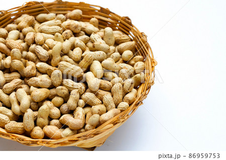 Raw peanuts in bamboo basket on white background. 86959753