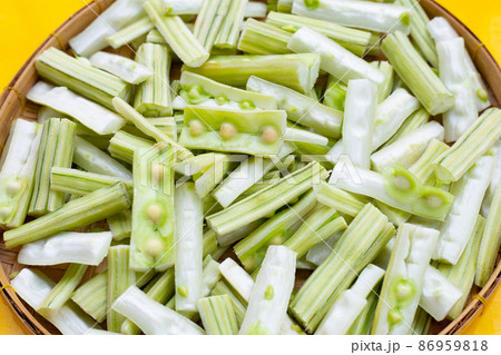 Moringa oleifera cut in pieces in bamboo weave plate on yellow background. Moringa oleifera cut in pieces in bamboo weave plate on yellow background. 86959818