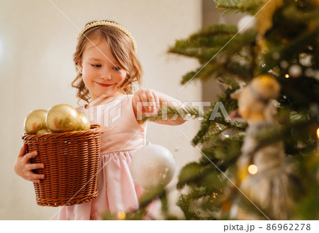 a cute little girl with toy basket for the Christmas tree. 86962278