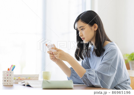 スマホを見ながら勉強をする女の子 高校生 中学生 86965196