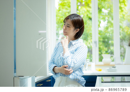 冷蔵庫を開けて悩む女性 86965789