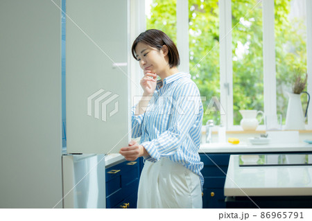 冷蔵庫を開けて悩む女性 冷蔵庫を開けて悩む女性 86965791