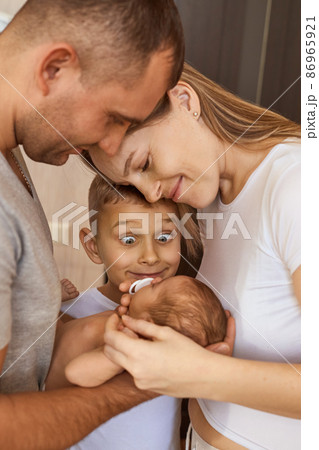 mother, father and daughter are looking at newborn baby mother, father and daughter are looking at newborn baby 86965921