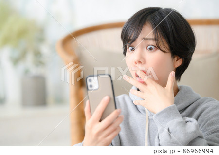 えーーーーとスマホを見て驚く女性 えーーーーとスマホを見て驚く女性 86966994