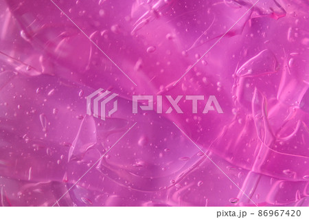 Texture of transparent violet pink gel with air bubbles and waves. Concept of skin moisturizing, body care, and prevention of viruses. Purple liquid beauty product closeup. Backdrop, flat lay 86967420