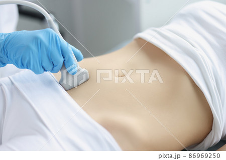 Hands on a woman's stomach, ultrasound abdominal cavity 86969250
