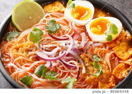 Mohinga is a rice noodle and fish soup from Myanmar and an essential part of Burmese cuisine closeup in the bowl. Horizontal Mohinga is a rice noodle and fish soup from Myanmar and an essential part of Burmese cuisine closeup in the bowl. Horizontal 86969348