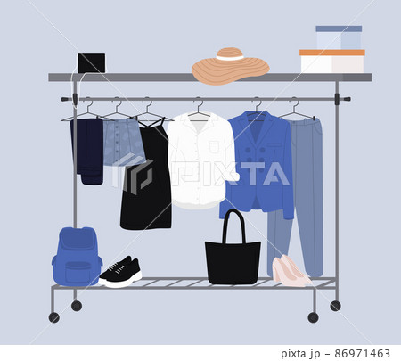 Stylish fashion clothes hanging on hangers on garment rack or rail. Fashion clothes and accessories on hanger rail. Fall, winter garments, footwear and bags. Women capsule wardrobe on racks. 86971463