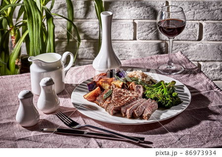 Beef steak with broccolini and potatoes 86973934