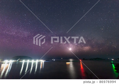 宮崎県日南市池ケ山から七つ岩と並ぶ小場島の上に広がる星空に横に流れる天の川と灯台と共に海を照らす金星 宮崎県日南市池ケ山から七つ岩と並ぶ小場島の上に広がる星空に横に流れる天の川と灯台と共に海を照らす金星 86976994