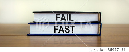 Books with text 'fail fast' on beautiful wooden table. White background. Business and fail fast concept. Copy space. Books with text 'fail fast' on beautiful wooden table. White background. Business and fail fast concept. Copy space. 86977131