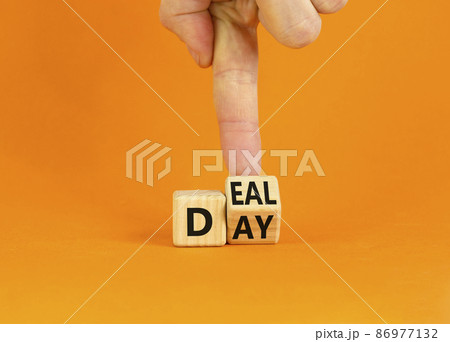 Deal of the day symbol. Businessman turns a wooden cube and changes the word 'day' to 'deal'. Beautiful orange background. Deal of the day and business concept. Copy space. Deal of the day symbol. Businessman turns a wooden cube and changes the word 'day' to 'deal'. Beautiful orange background. Deal of the day and business concept. Copy space. 86977132