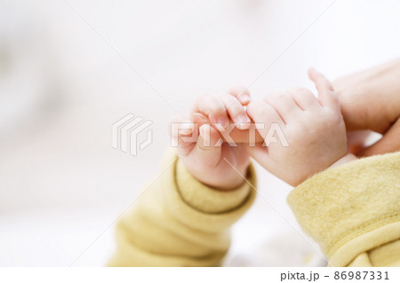 お母さんの指を握るアジア人の赤ちゃんの手元 86987331