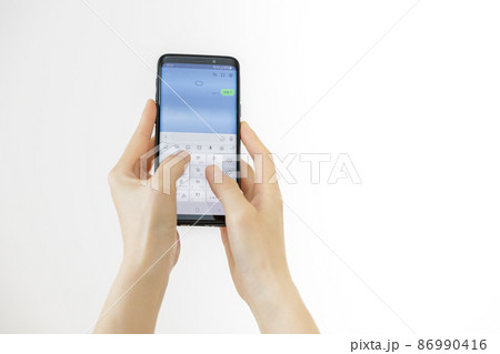 スマホのメッセージアプリを使っている手元 86990416