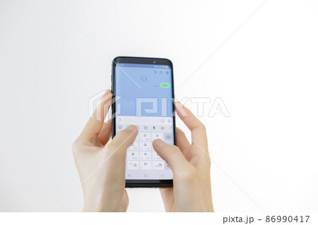 スマホのメッセージアプリを使っている手元 86990417
