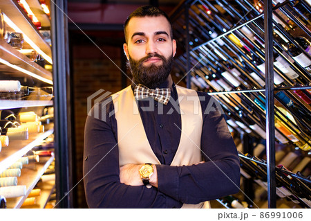 arabian man sommelier appreciating drink in lux hotel 86991006