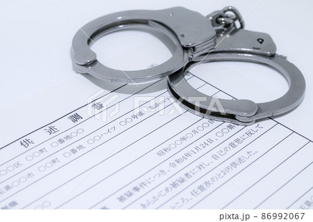 銀色の手錠と供述調書・取調イメージ 86992067