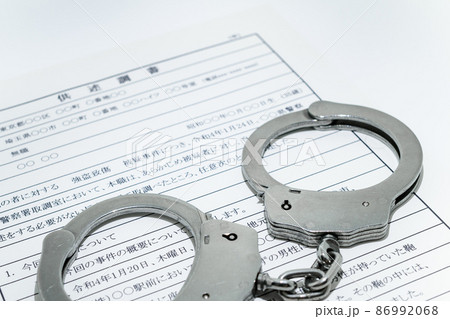 銀色の手錠と供述調書・取調イメージ 86992068
