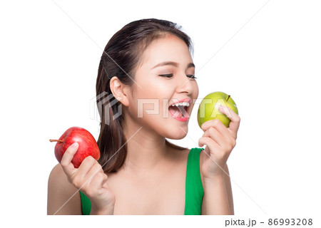 Young beautiful asian woman eating fresh green apple on white background 86993208
