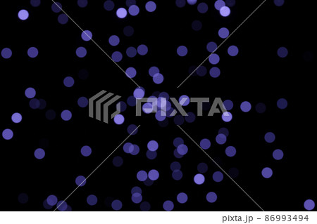 Defocused bokeh lights on black background, an abstract naturally blurred backdrop for Valentines Day or birthday party. Festive light texture. Violet blue garland in blur. Color 2022 Defocused bokeh lights on black background, an abstract naturally blurred backdrop for Valentines Day or birthday party. Festive light texture. Violet blue garland in blur. Color 2022 86993494