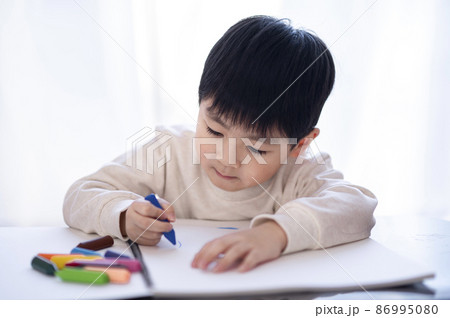 スケッチブックにクレヨンで絵を描く4歳の男の子 スケッチブックにクレヨンで絵を描く4歳の男の子 86995080