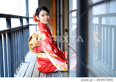 古民家のベランダに座っている20代の着物を着た女性 86997866