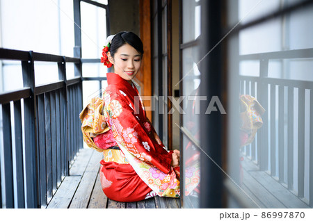 古民家のベランダに座っている20代の着物を着た女性 86997870