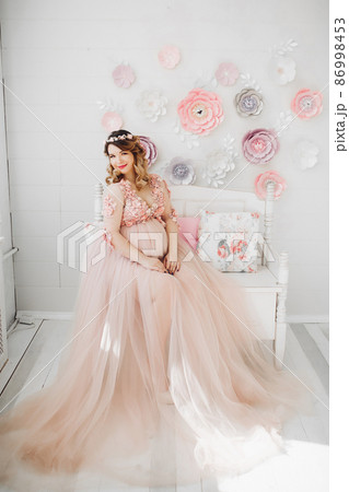 Pregnant woman sitting on big decorated vine Pregnant woman sitting on big decorated vine 86998453