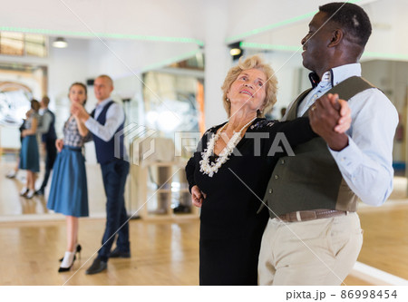 Man and senior woman dancing waltz in studio Man and senior woman dancing waltz in studio 86998454