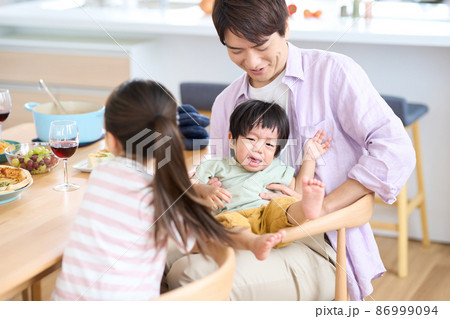 泣きじゃくる1歳児をあやす姉 86999094