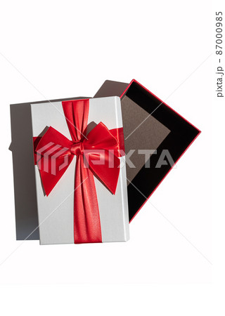 Opened gift box with lid and red ribbon isolated on white 87000985