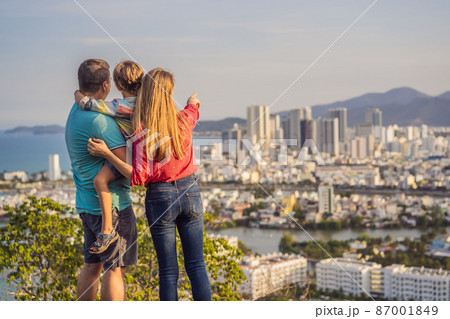 Happy family tourists on the background of Nha Trang city. Travel to Vietnam with kids Concept Happy family tourists on the background of Nha Trang city. Travel to Vietnam with kids Concept 87001849