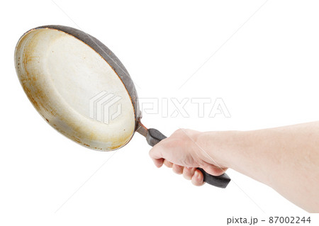 bare caucasian hand holding empty old aluminium frying pan 87002244